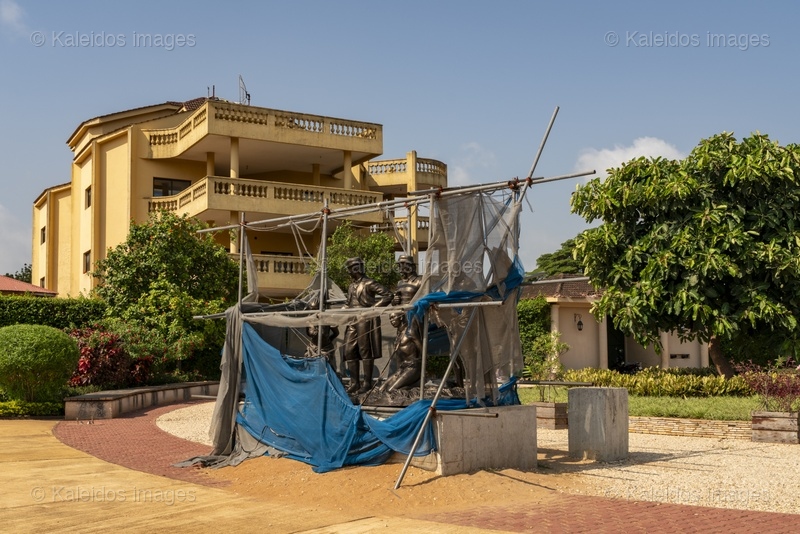 Place des Enchères Ouidah ; Place Chacha slave market Benin ; bronze sculptures slave trade ; spheres ground memorial Ouidah ; monumental heads Xweda Fon Yoruba ; memorial public art West Africa ; night lighting Ouidah square ; red laterite ground ; de Souza house Singbomey ; Afro-Brazilian heritage Ouidah ; Benin Revealed program