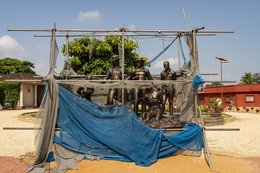 Place-des-Enchères-Ouidah-;-Place-Chacha-slave-market-Benin-;-bronze-sculptures-slave-trade-;-spheres-ground-memorial-Ouidah-;-monumental-heads-Xweda-Fon-Yoruba-;-memorial-public-art-West-Africa-;-night-lighting-Ouidah-square-;-red-laterite-ground-;-de-Souza-house-Singbomey-;-Afro-Brazilian-heritage-Ouidah-;-Benin-Revealed-program