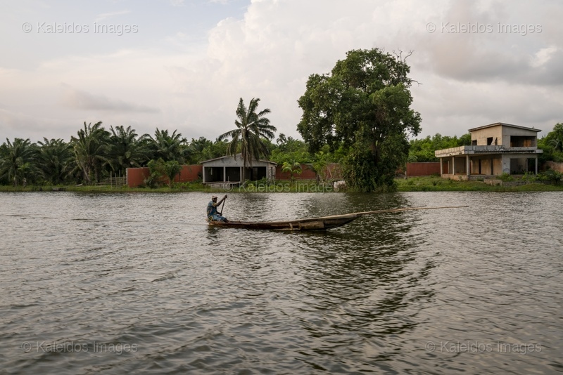 Lake Toho;Ouidah;Benin;West Africa;fisherman;Man;pirogue;paddle;Shirt;lake crossing;pole;overcast sky;traditional transport;everyday life;West Africa;Tarek Charara;Kaleidos;Kaleidos images;La parole à l'image