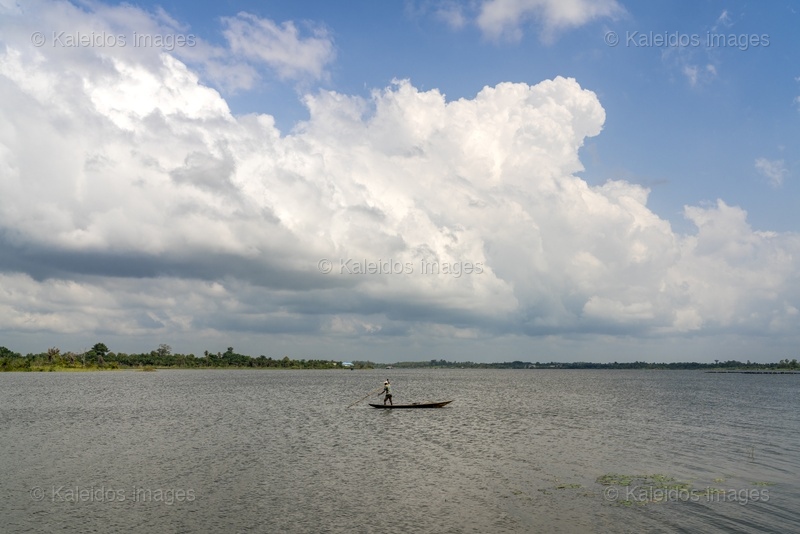 Lake Toho;Ouidah;Benin;West Africa;fisherman;pirogue;standing;paddle;cumulus;dramatic sky;open water;water lily;lake landscape;traditional fishing;solitude;Tarek Charara;Kaleidos;Kaleidos images;La parole à l'image