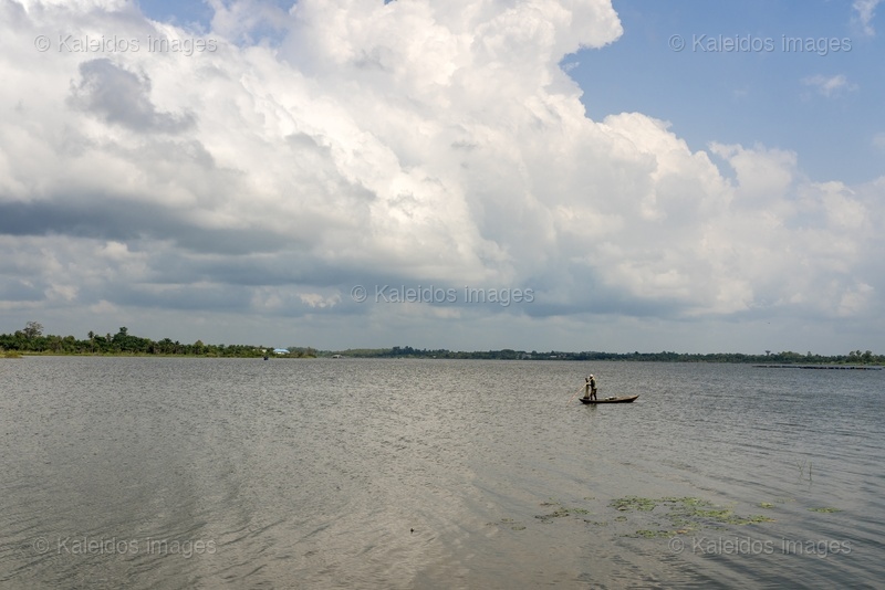 Lake Toho;Ouidah;Benin;West Africa;fisherman;pirogue;standing;paddle;cumulus;dramatic sky;open water;water lily;lake landscape;traditional fishing;solitude;Tarek Charara;Kaleidos;Kaleidos images;La parole à l'image