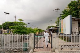 Artisan-market;-Benin;-Boubou;-Cotonou;-Entrance;-Fence;-Gate;-Gbegamey;-Kaleidos;-Kaleidos-images;-La-parole-à-limage;-Marché-des-arts;-Railway;-Red-fascia-band;-Solar-street-lamp;-Storm-clouds;-Tarek-Charara