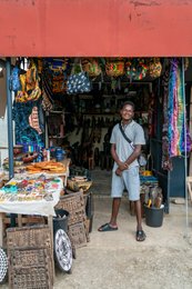 Artisan;-Artisan-market;-Basket;-Benin;-Cotonou;-Craft-stall;-Gbegamey;-Kaleidos;-Kaleidos-images;-La-parole-à-limage;-Marché-des-arts;-Mask;-Red-fascia-band;-Smile;-Statuette;-Tarek-Charara;-Woven-bag