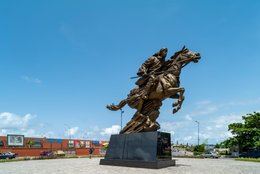 Benin;-Billboard;-Bio-Guéra;-Cast-copper;-Colonial-resistance;-Commercial-building;-Cotonou;-Equestrian-statue;-Erevan-junction;-Horseman;-Kaleidos;-Kaleidos-images;-La-parole-à-limage;-Monument;-National-hero;-Rearing-horse;-Sculpture;-Steel-structure;-Tarek-Charara;-West-Africa