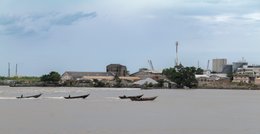 Antenna;-Benin;-Buildings;-Clouds;-Cloudy-sky;-Cotonou;-Kaleidos;-Kaleidos-images;-La-parole-à-limage;-Lagoon;-Lagoon-front;-Littoral;-Navigation;-Opposite-bank;-Pirogues;-Stories-Pictures;-Tarek-Charara;-Wake;-Warehouses;-Water;-West-Africa
