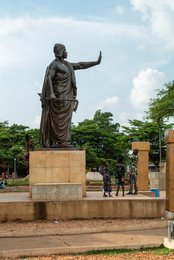 Abomey;-Béhanzin;-Benin;-Bronze;-Colonial-resistance;-Cultural-heritage;-Dahomey;-Kaleidos;-Kaleidos-images;-King;-La-parole-à-limage;-Mansudae;-Monument;-Pagne;-Passersby;-Place-Goho;-Sculptural-detail;-Sculpture;-Side-view;-Statue;-Stories-Pictures;-Tarek-Charara;-Vegetation